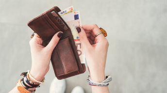 Frau nimmt Geld aus Geldbörse