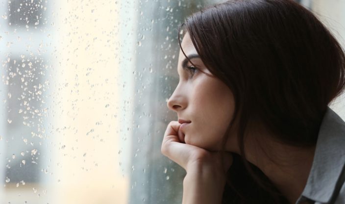 Frau schaut aus Fenster