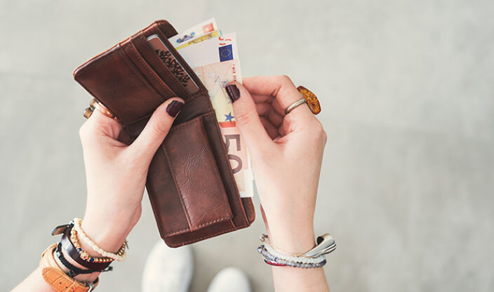 Frau nimmt Geld aus Geldbörse