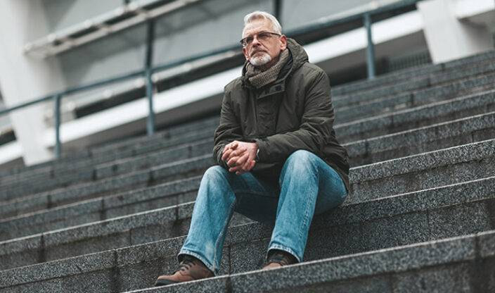 Mann sitzt auf einer Treppe