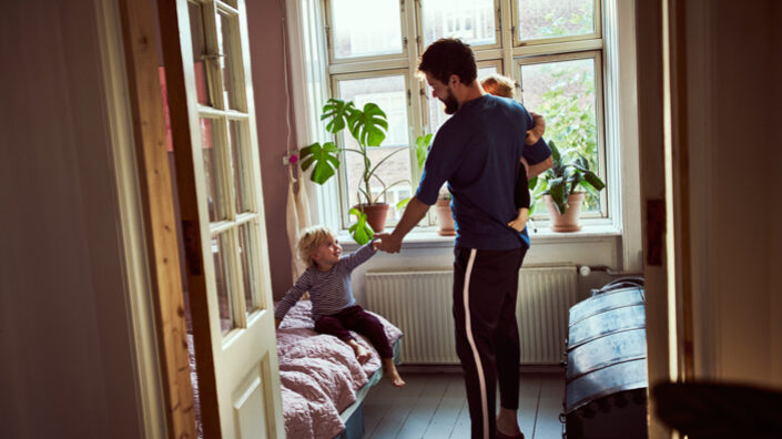 Vater mit Kindern im Zimmer