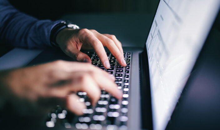 Tippende Hände vor Laptop
