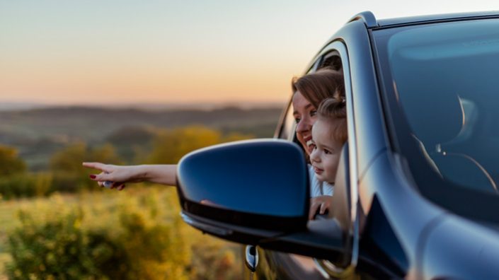 Mutter und Kind schauen aus Autofenster