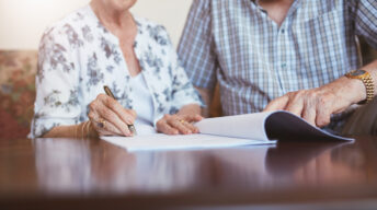 Älteres Ehepaar unterschreibt Vertrag