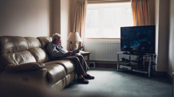Rentner sitzt vor großem Fernseher