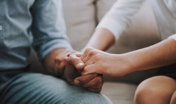 Frau hält Hand eines Mannes