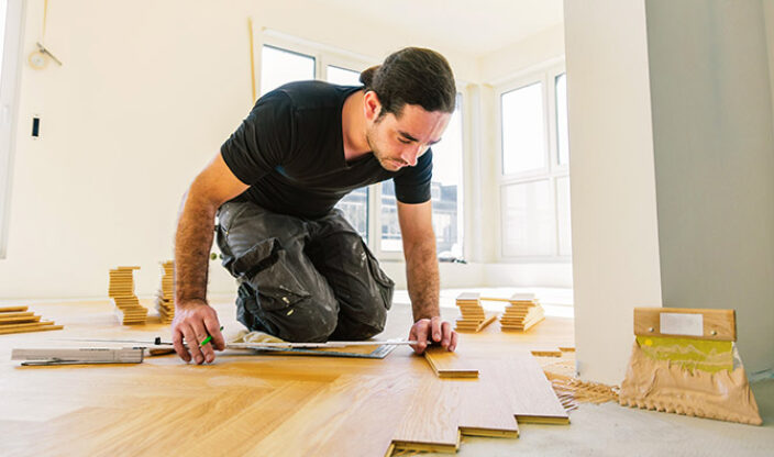 Handwerker verlegt Parkett