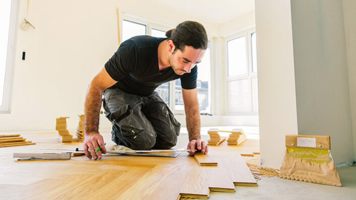 Handwerker verlegt Parkett