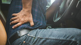Person greift sich an den Rücken