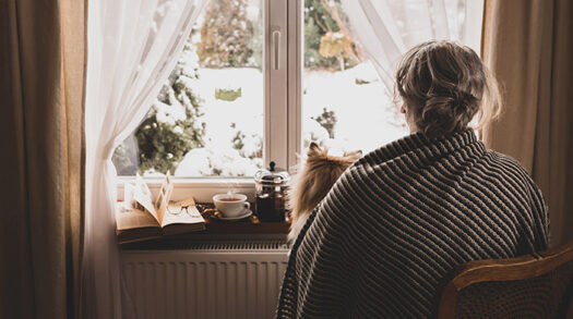 Einsamkeit Frau schaut aus Fenster
