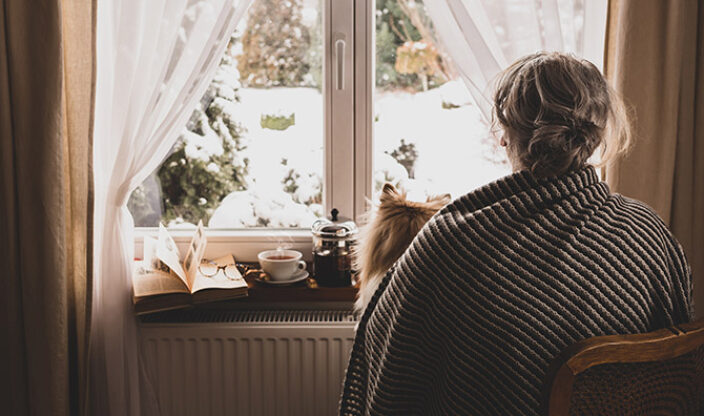 Einsamkeit Frau schaut aus Fenster
