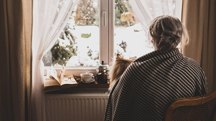 Einsamkeit Frau schaut aus Fenster