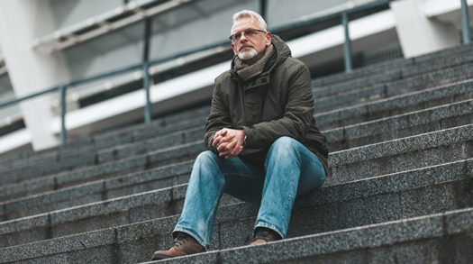 Mann sitzt auf einer Treppe