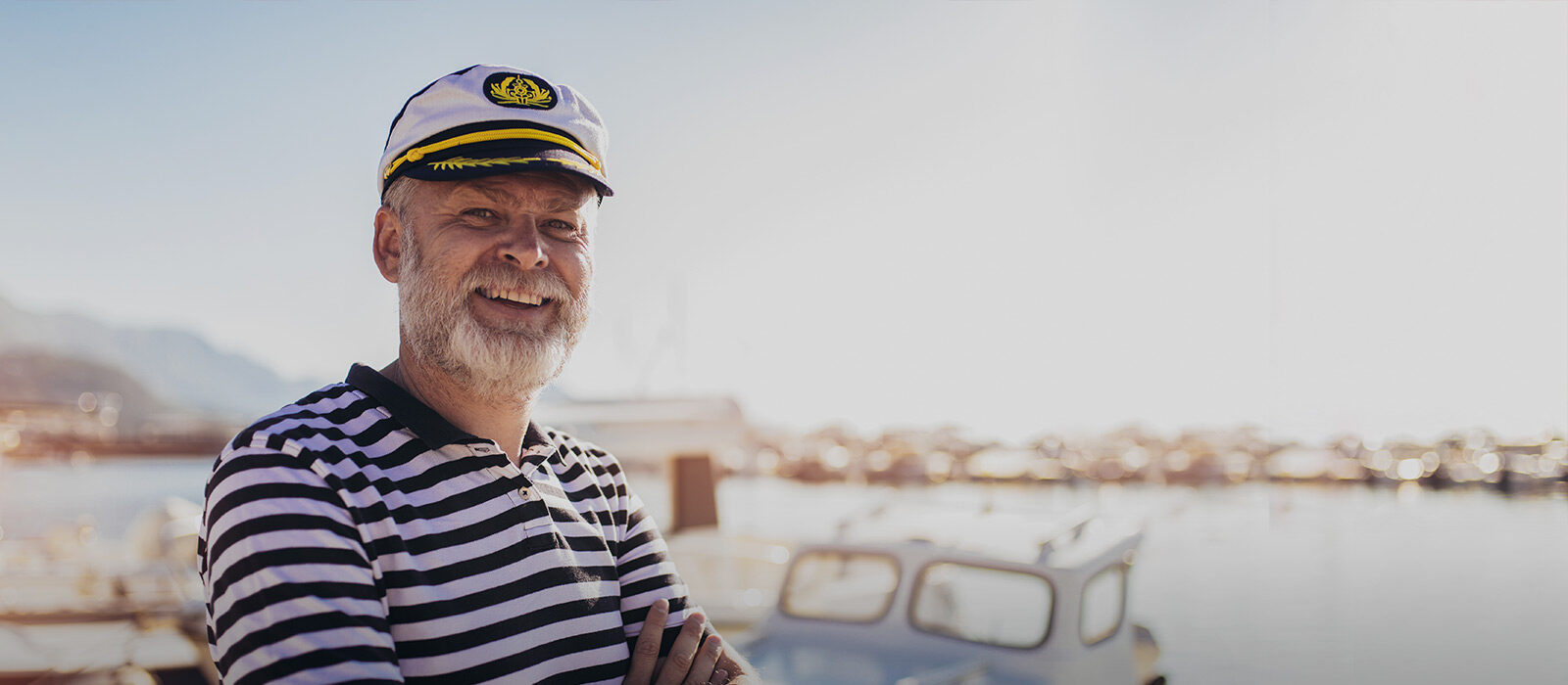 Älterer Herr steht vor seinem Boot