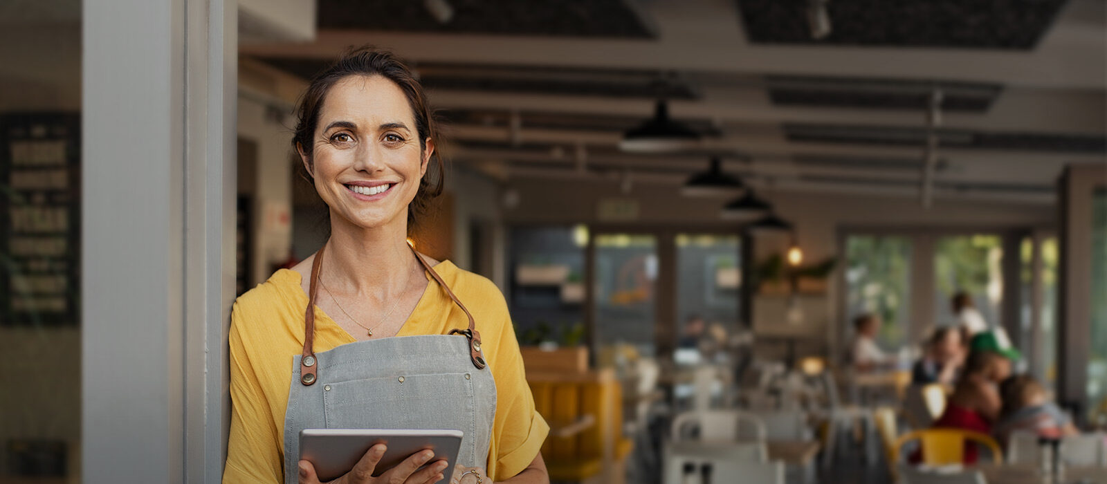 Junge Frau vor eigenem Cafe